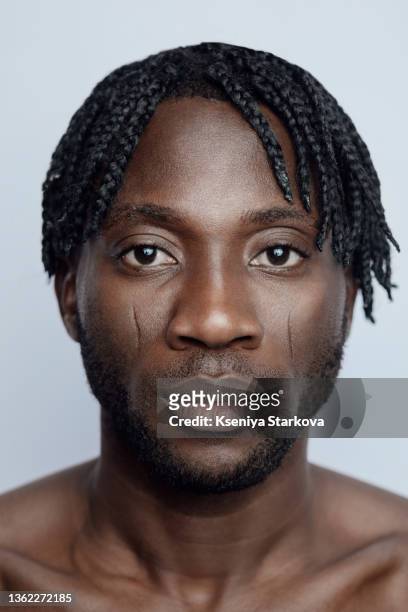 black man with short pigtails in hair on a white background in the studio close-up beauty portrait - strong hair 個照片及圖片檔
