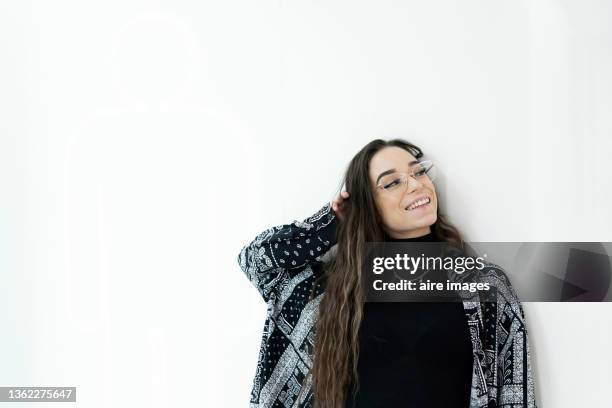 close-up of young woman looking at the camera and smiling while leaning on wall indoors. - entry draft portraits stock pictures, royalty-free photos & images