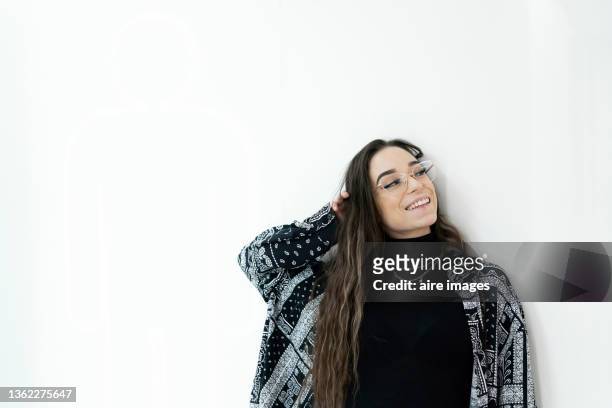 close-up of young woman looking at the camera and smiling while leaning on wall indoors. - entry draft portraits bildbanksfoton och bilder