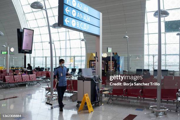 An airport employee works at the departure terminal at Dubai International Airport on January 01, 2022 in Dubai, UAE. Inter-country journeys made...
