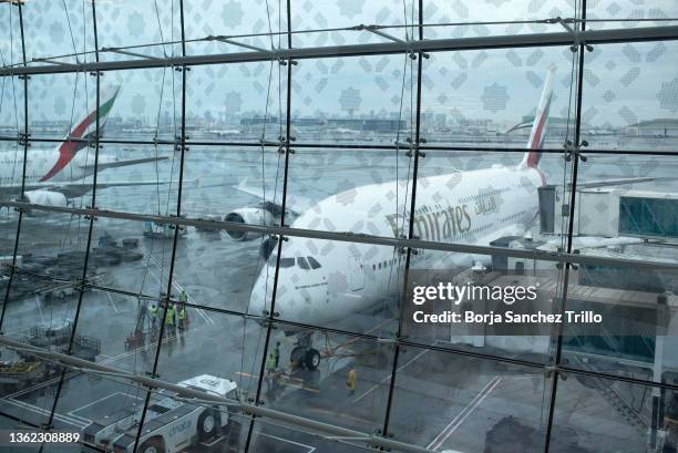 Airport employees prepare an Emirates airplane for a flight at Dubai International Airport on January 01, 2022 in Dubai, UAE. Inter-country journeys...