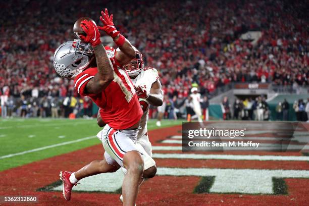 Jaxon Smith-Njigba of the Ohio State Buckeyes catches a touchdown pass as Malone Mataele of the Utah Utes defends during the fourth quarter in the...