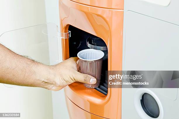 getting some fresh coffee out of a machine - coin operated stockfoto's en -beelden