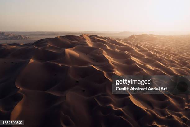 drone image showing a sand dune in the desert at sunset, abu dhabi, united arab emirates - sand dune stock pictures, royalty-free photos & images