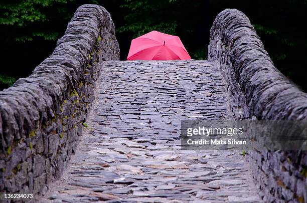 roman bridge and red umbrella - roman bridge stock-fotos und bilder