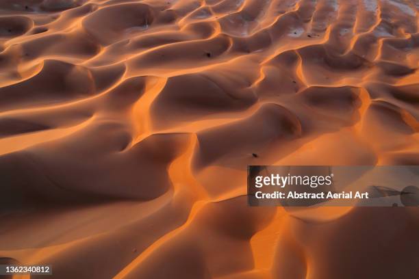 flowing sand dunes in the arabian desert photographed by drone, abu dhabi, united arab emirates - sable ondulé photos et images de collection
