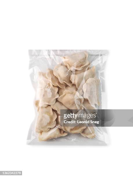 frozen uncooked pelmeni, vareniki (dumplings) top view in a bag (packaging) from recycled plastic on white background isolated closeup. selective focus - frozen food stock pictures, royalty-free photos & images