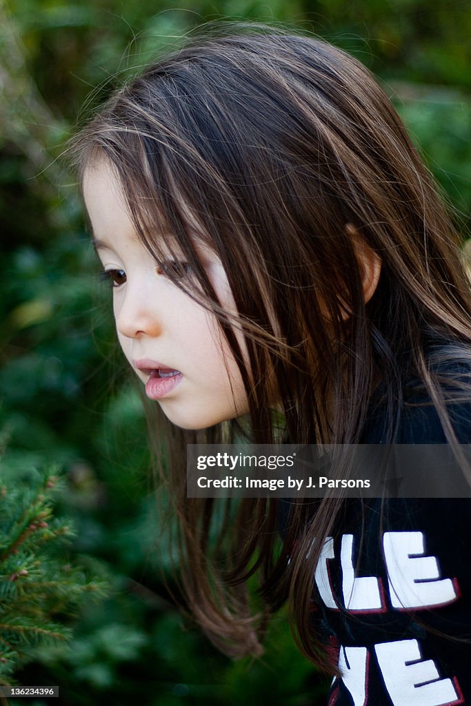 Portrait of girl against green tree