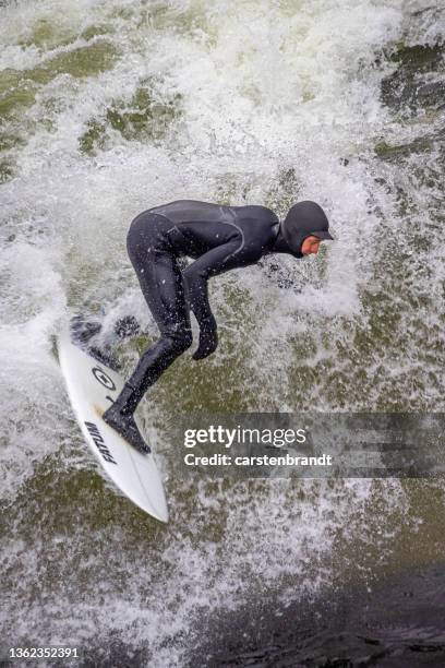 young man surfing on a river in the center of munich - eisbach river stock pictures, royalty-free photos & images