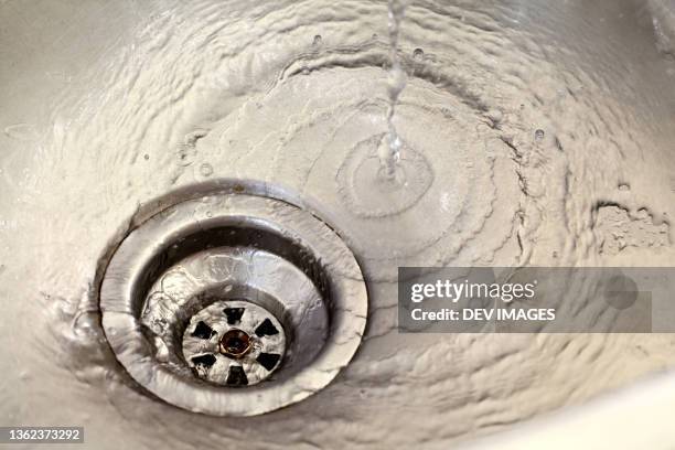 kitchen sink with flowing water - desperdício de água imagens e fotografias de stock