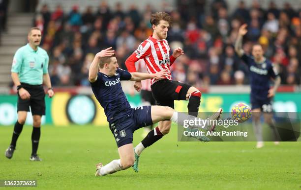 Matt Target of Aston Villa battles for possession with Mathias Jensen of Brentford during the Premier League match between Brentford and Aston Villa...