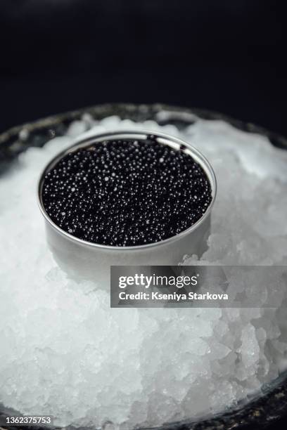 black caviar in a silver jar on ice on a dark background - caviar stock pictures, royalty-free photos & images