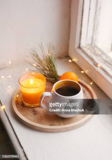 cozy winter home interior details, cup of coffee, wooden tray, tangerine and candle. window sill. still life for christmas. - coffee christmas ストックフォトと画像