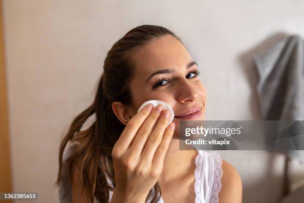 young woman removing makeup - removing make up stock pictures, royalty-free photos & images