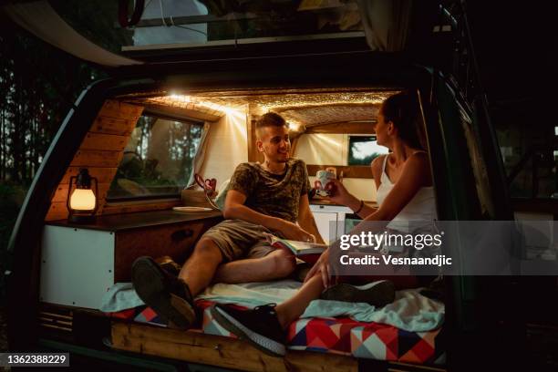 young couple with camper at road trip - motorhome night stock pictures, royalty-free photos & images