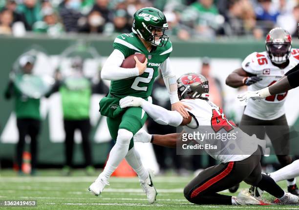 Zach Wilson of the New York Jets scrambles away from the defense of Ross Cockrell of the Tampa Bay Buccaneers in the second quarter of the game at...