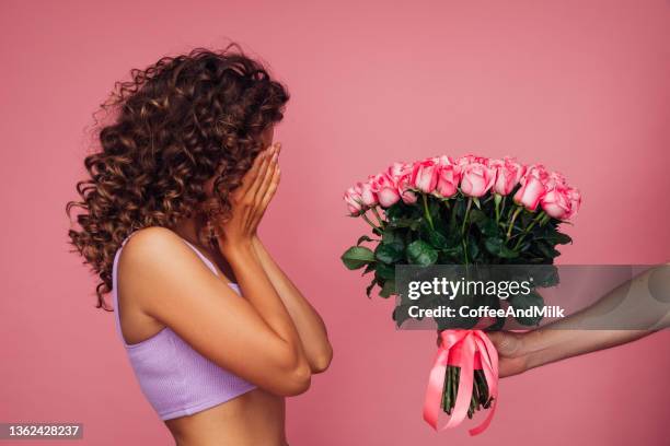 beautiful woman receiving a bouquet of flowers - receiving flowers stock pictures, royalty-free photos & images