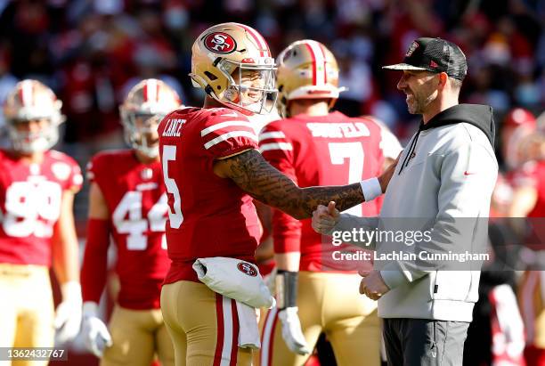 Trey Lance of the San Francisco 49ers and Head Coach Kyle Shanahan of the San Francisco 49ers talk before the game against the Houston Texans at...