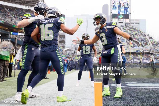 Tyler Lockett of the Seattle Seahawks celebrates with Russell Wilson after catching a pass for a touchdown during the second quarter against the...