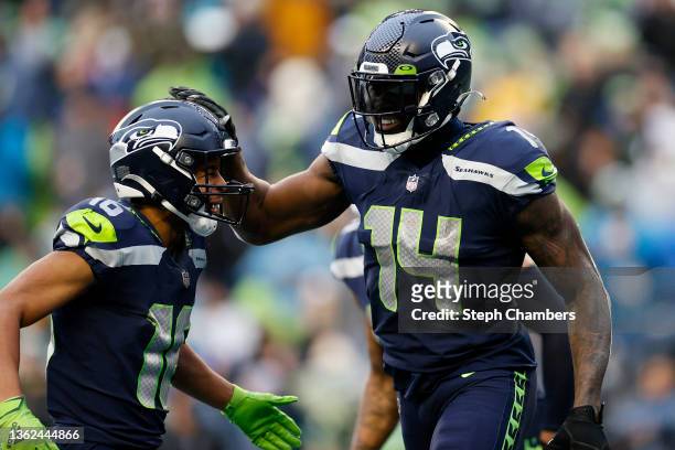 Metcalf of the Seattle Seahawks celebrates his touchdown catch with Tyler Lockett during the third quarter against the Detroit Lions at Lumen Field...