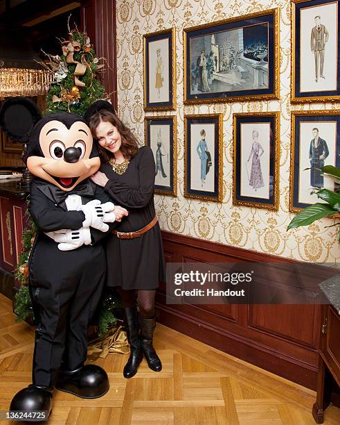 In this handout photo provided by Disney Parks, Oscar-nominated actress Lesley Ann Warren poses with Mickey Mouse beside original costume sketches...