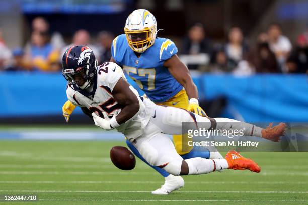 Melvin Gordon of the Denver Broncos has a pass broken up by Amen Ogbongbemiga of the Los Angeles Chargers in the fourth quarter of the game at SoFi...
