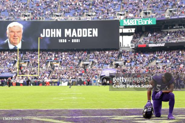 Tyus Bowser of the Baltimore Ravens kneels in the end zone before a moment of silence is recognized for former NFL coach John Madden before the game...