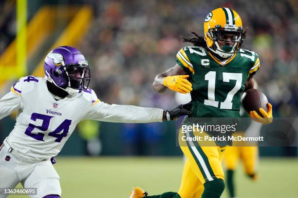 Wide receiver Davante Adams of the Green Bay Packers catches a pass for a first down as cornerback Mackensie Alexander of the Minnesota Vikings...