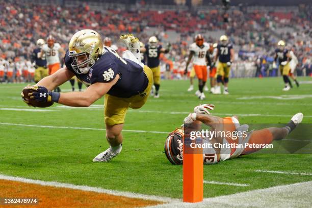 Tight end Michael Mayer of the Notre Dame Fighting Irish dives to score a touchdown past Kolby Harvell-Peel of the Oklahoma State Cowboys in the...