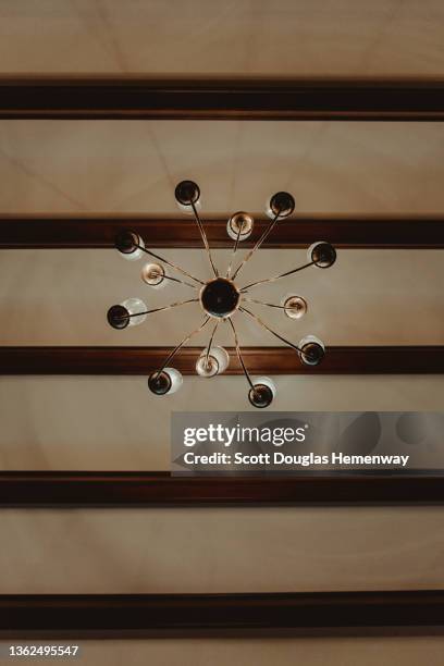 under a chandelier - fitting stockfoto's en -beelden