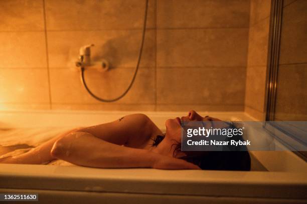 the beautiful woman enjoys the bath at home with a candles - beauty salon ukraine stock pictures, royalty-free photos & images