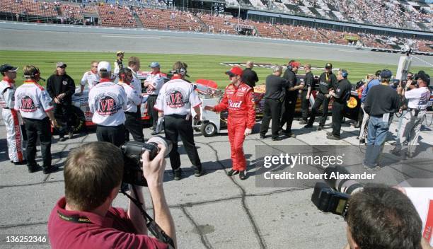 Driver Dale Earnhardt Jr. Talks with a member of driver John Andretti's crew prior to the 2005 Daytona 500 on February 20, 2005 at the Daytona...