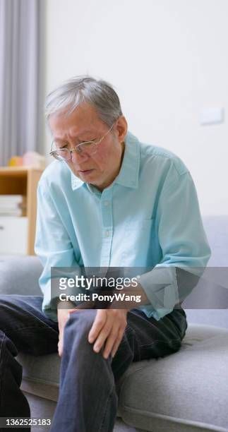 man holding knee with pain - human joint stock pictures, royalty-free photos & images