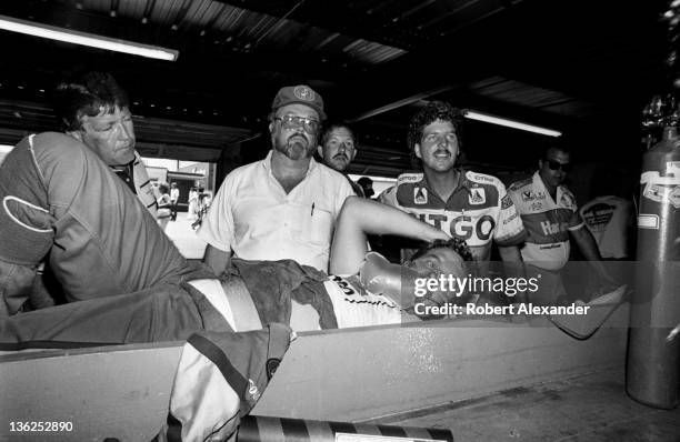 Driver Kyle Petty is administered oxygen in the Daytona International Speedway garage as he cools off after completing the 1987 Firecracker 400 on...