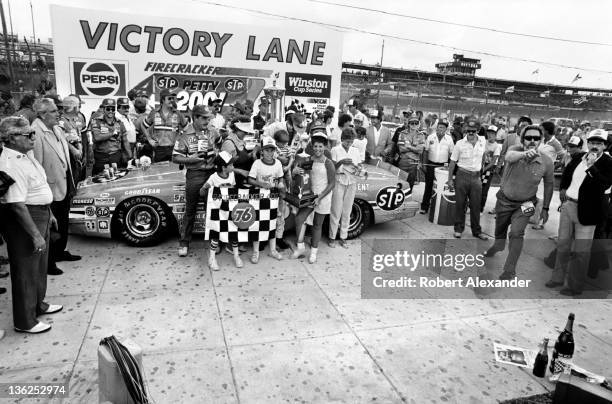 Richard Petty, driver of the STP Pontiac, celebrates with family members in Victory Lane at the Daytona International Speedway on July 4, 1984 in...