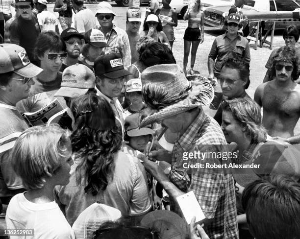Richard Petty, driver of the STP Pontiac, signs autographs in the Daytona International Speedway infield prior to the 1980 Firecracker 400 on July 4,...