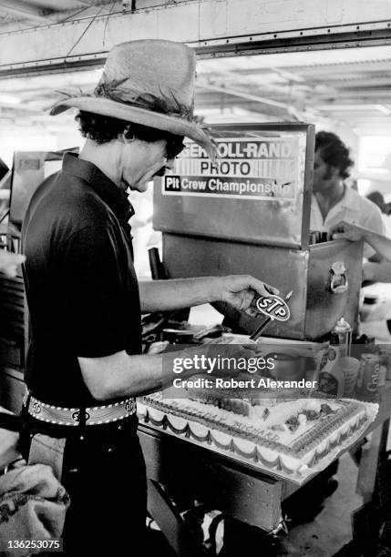 Richard Petty, driver of the STP Pontiac, cuts his birthday cake in the Daytona International Speedway garage prior to the 1986 Firecracker 400 on...