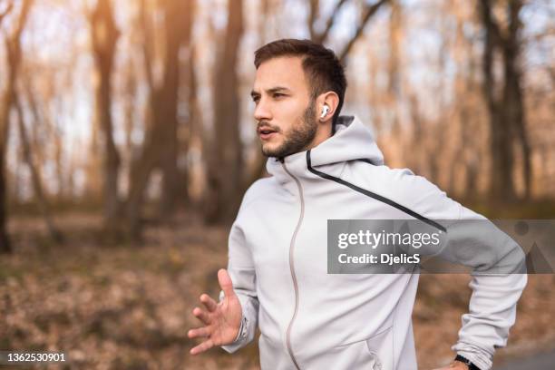 young sportsman running in nature. - wireless headphones stock pictures, royalty-free photos & images