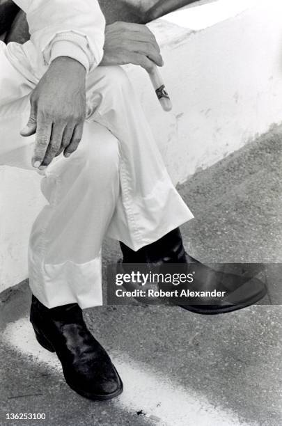 Richard Petty, driver of the STP Pontiac, sits on the pit road wall at the Daytona International Speedway as he watches cars qualify for the 1980...