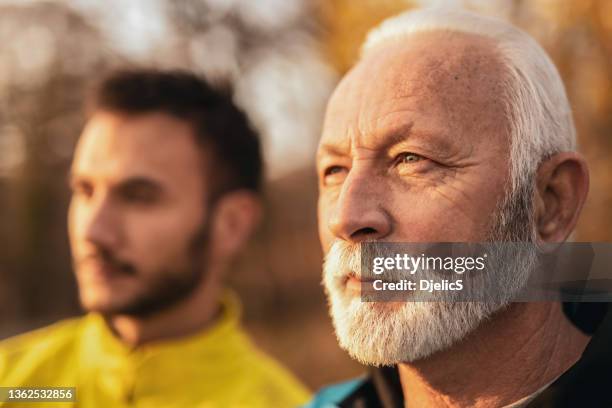 close-up of senior man sun gazing and day dreaming with his son in nature. - contemplation family stockfoto's en -beelden