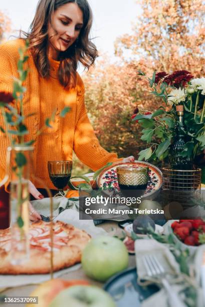 a beautiful young girl serves the table. autumn table outside. - party pies imagens e fotografias de stock