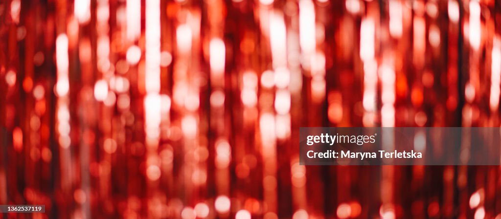 Festive blurred red background with glitter. Festive background. Blurred background. Red shiny background. Banner.