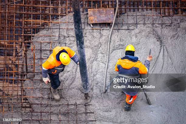 workers pouring concrete - concrete stock pictures, royalty-free photos & images