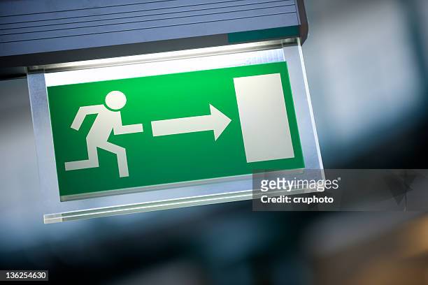 close-up of green emergency exit light sign - escape stockfoto's en -beelden
