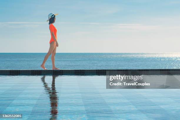 woman summer fashion. long legs. healthy skin in bikini. sun hat. sunglasses sunbathing by swimming pool on travel holidays vacation. beauty. wellness. lifestyle - woman one casual walking stylish stock-fotos und bilder