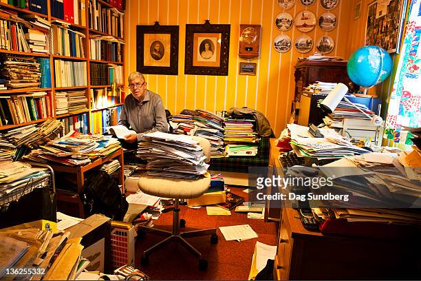 man working in his study - messy fotografías e imágenes de stock