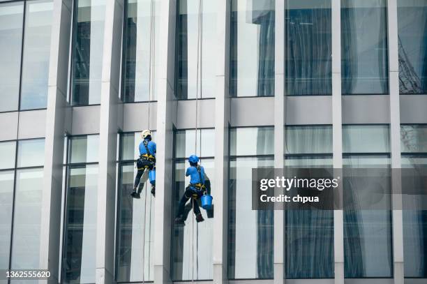 window cleaners is working on the high rises office building facade - service level high stock pictures, royalty-free photos & images