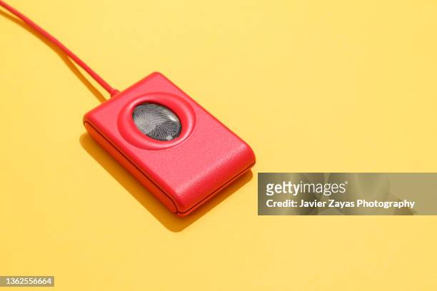 red fingerprint scanner on yellow background - fingerprint scanner stock pictures, royalty-free photos & images