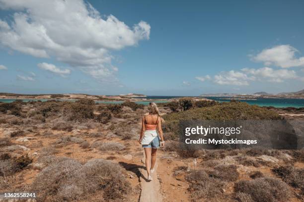 young woman walks towards the sea in greece - a separate peace stock pictures, royalty-free photos & images