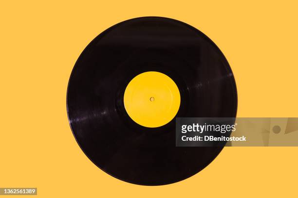 music vinyl record with yellow label on yellow background. music, disco, sound, retro, vintage, analog and analog record concept. - colors soundtrack fotografías e imágenes de stock